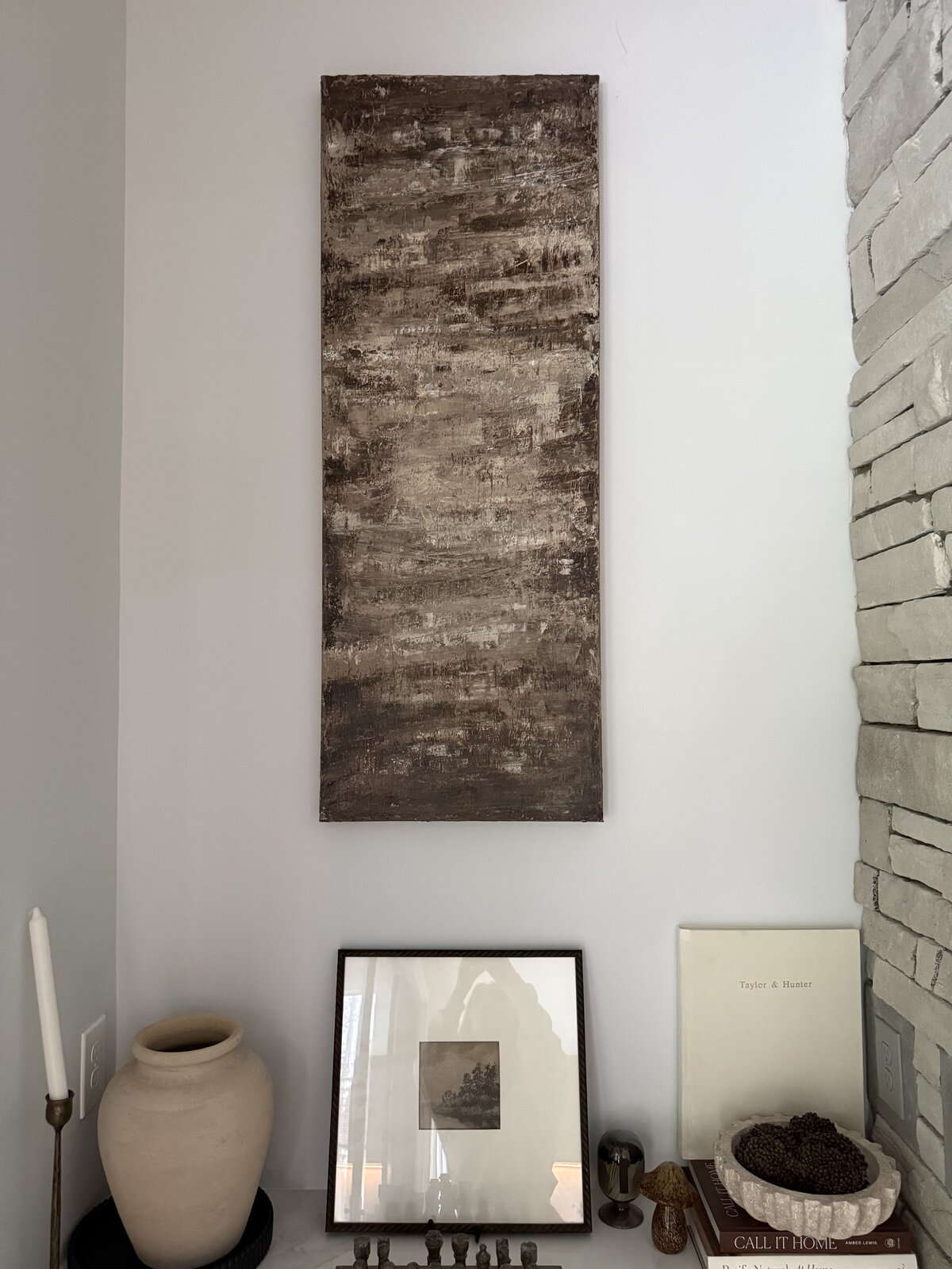 The same painting, framed by a stone fireplace in a quiet room