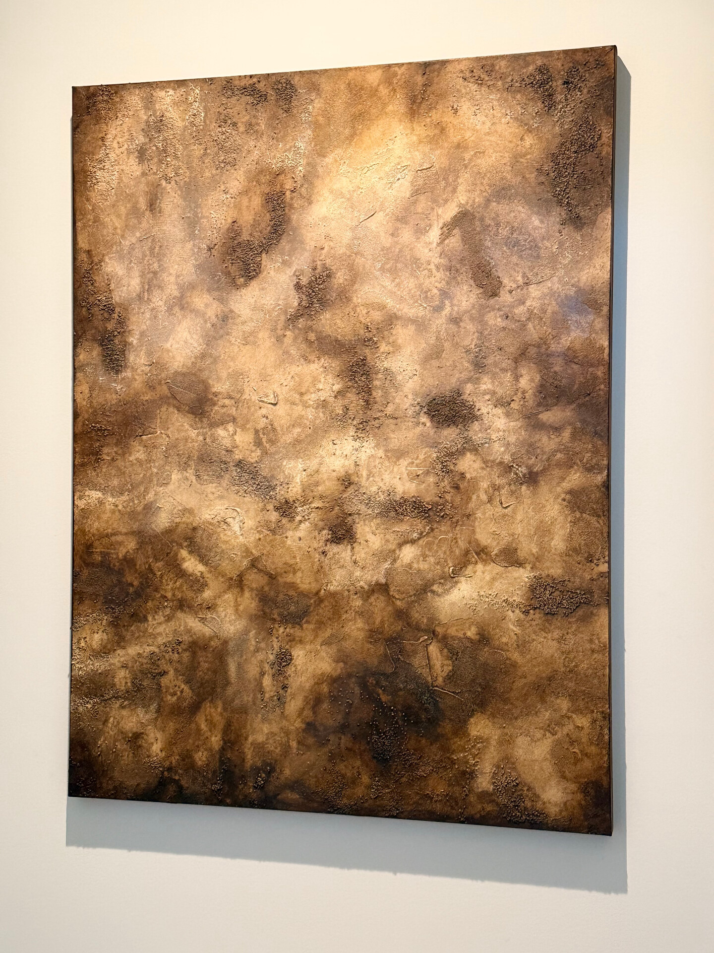Aged Earth hung on a neutral wall in a quiet, styled room